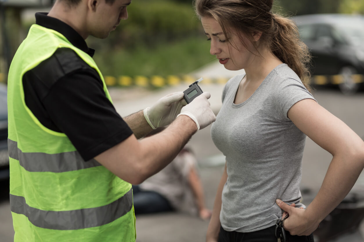 Female being tested with a breathalyzer for drugs or alcohol.