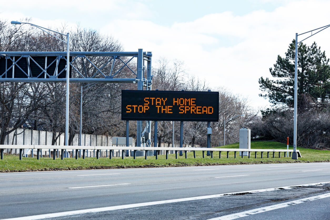 Sign on county highway with stay-at-home order, that says "Stay Home, Stop the Spread"