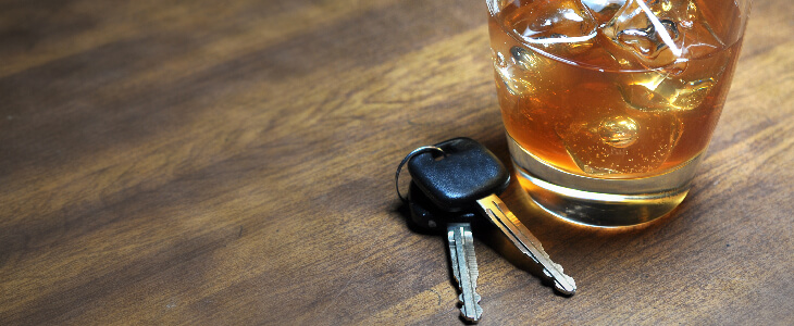 Car keys and an alcoholic drink resting on a table