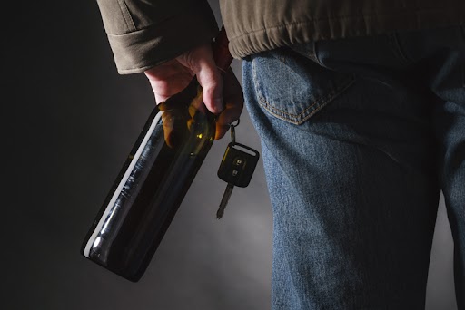 man holding beer and car keys