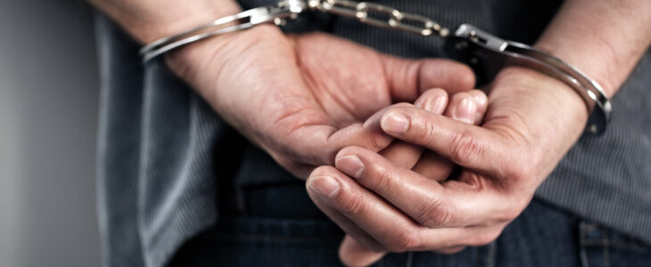 Arrested man in handcuffs with hands behind back