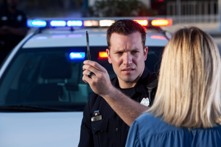 Police officer stopping blonde woman for DWI.