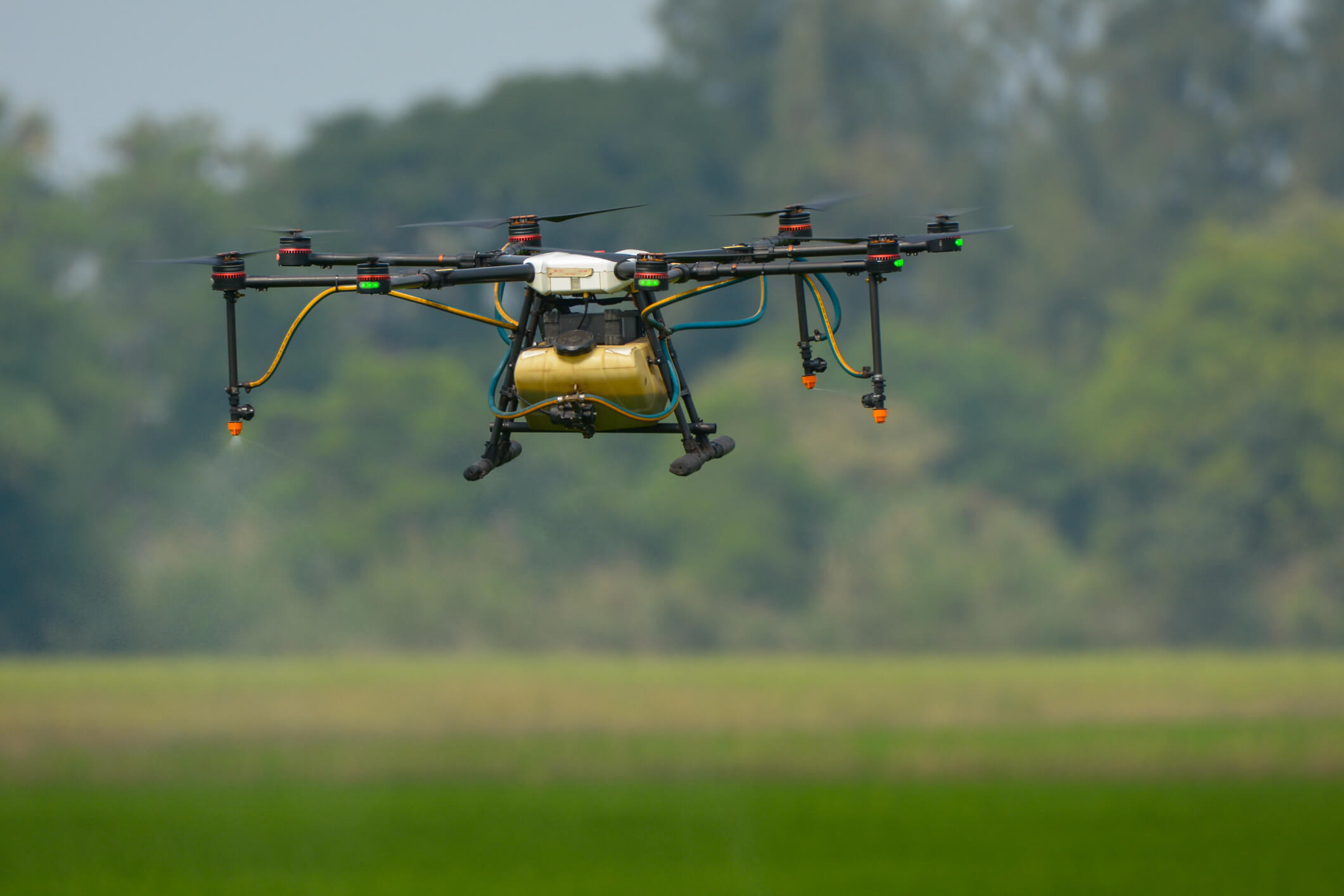 One of many drones flying over a field.