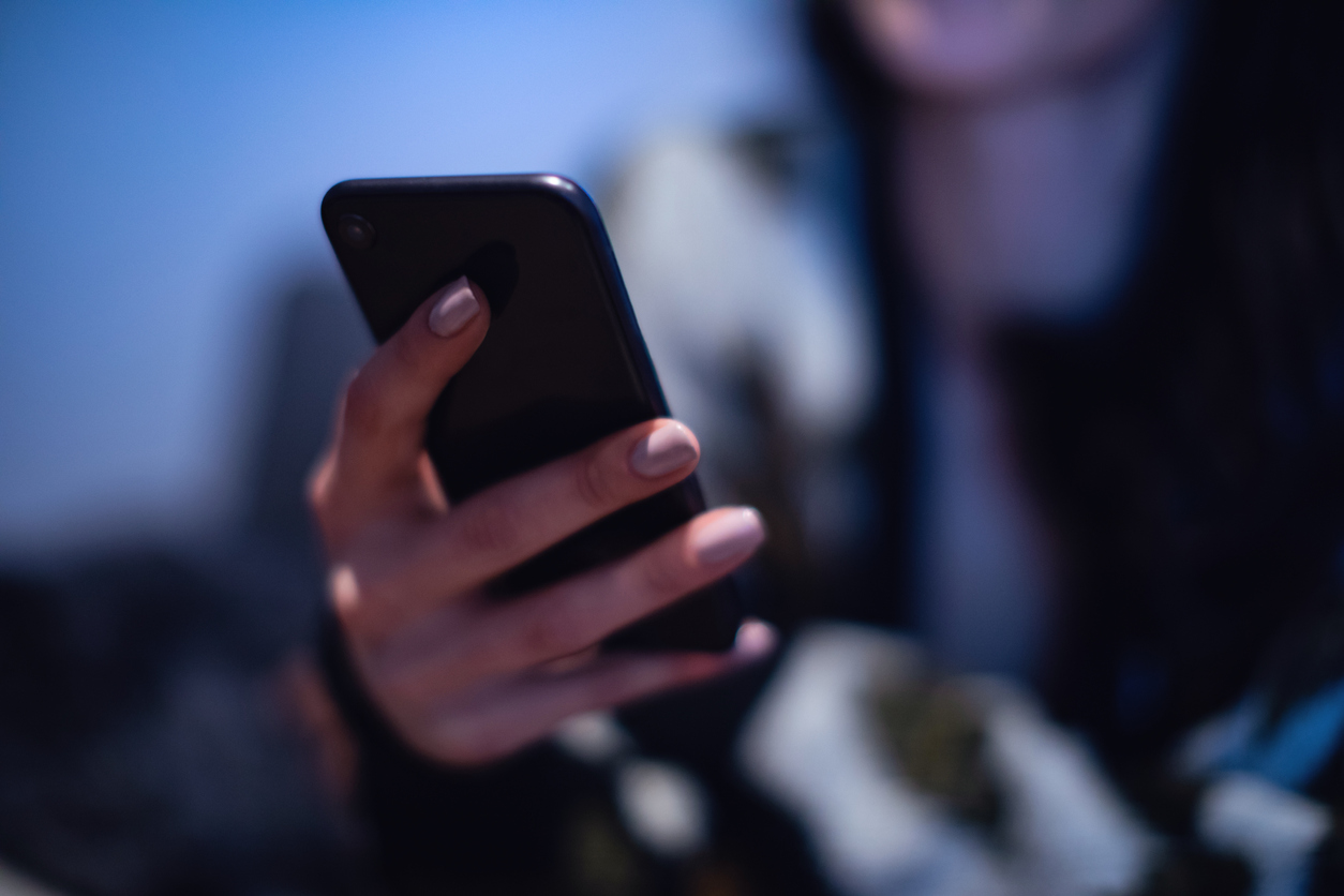 Woman holding her cell phone, cyberstalking