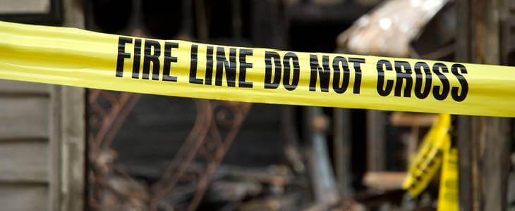 An arson crime scene with police tape covering it