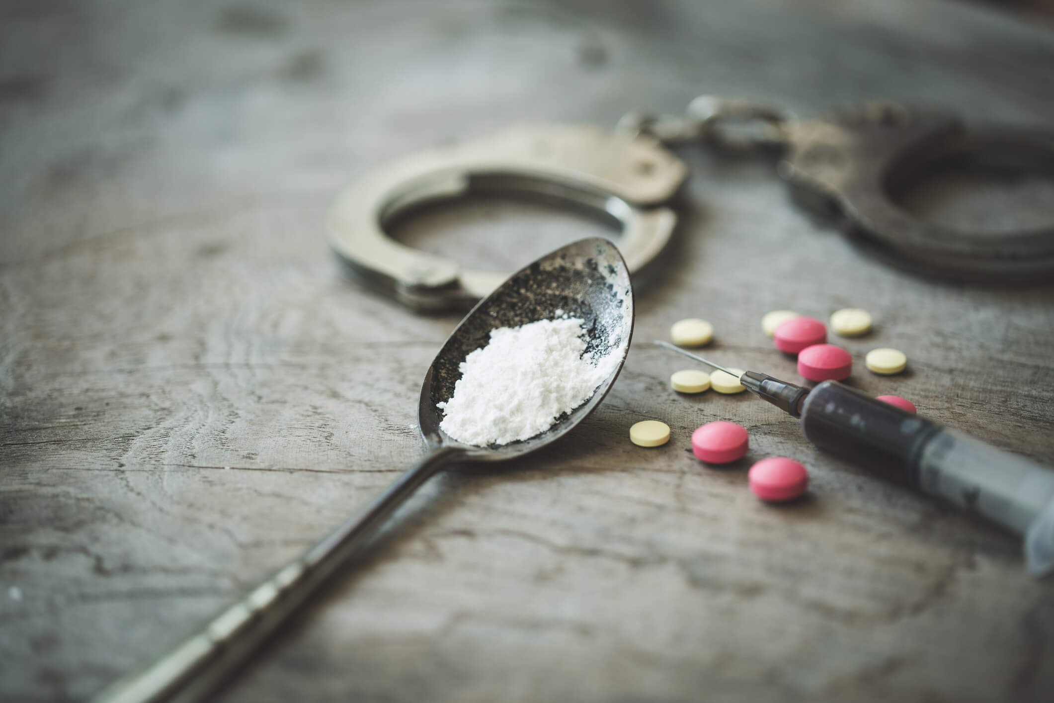 Handcuffs, drugs and syringes on wooden table, Law and police concept, World Anti-drug Day - Image