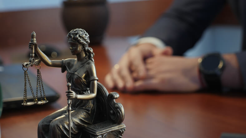Criminal defense attorney with Justice statue