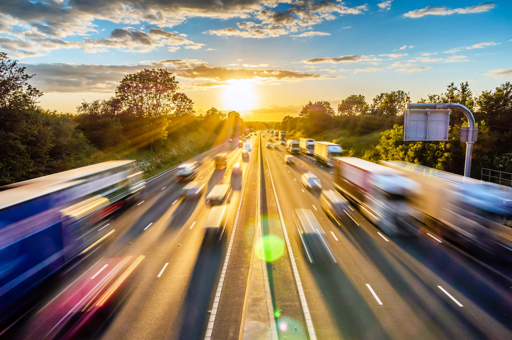heavy traffic moving at speed on NC motorway in at sunset.