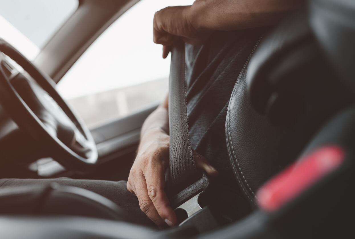 male hand fastens the seat belt of car. Close your car seat belt while sitting inside the car before driving and take a safe journey. Closeup shot of male driver fastens seat belt.