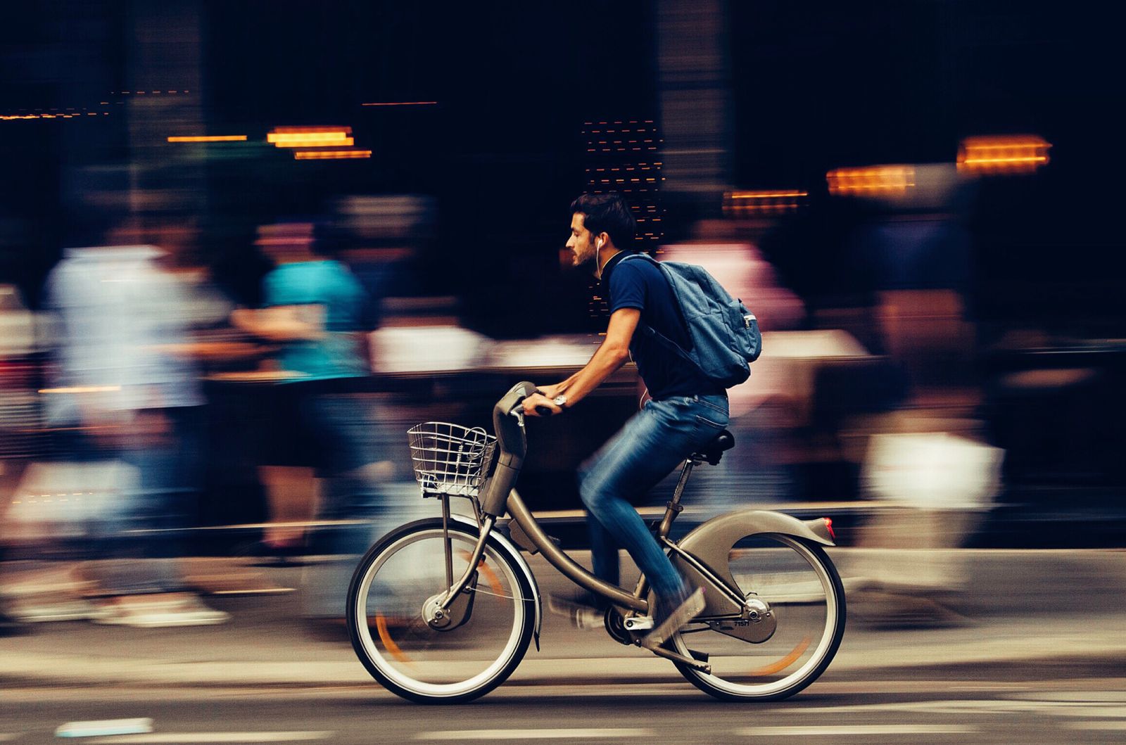 Person riding a bicycle on a city street in the evening